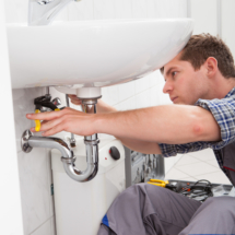 Male plumber working on a bathroom sink